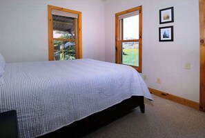 A bedroom with a bed, two windows, and two framed pictures on the wall. - Horseshoe House, Close to shuttle, Pitchfork. (Mt. Crested Butte)