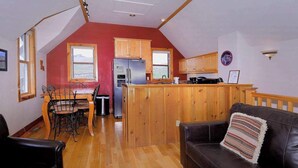 Un espace de vie de style loft comprenant un coin repas, une cuisine et un coin salon confortable.