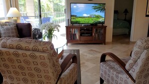 Un soggiorno con mobili decorati, una televisione e vista sull'esterno.