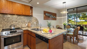 A modern kitchen with granite countertops, stainless steel appliances, and wooden cabinets.