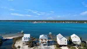 A coastal property with a dock, beach, and clear blue water. - Good Time Charlie by GSVR | Lagoonfront Home w/ Pool, Firepit & Beach Access + FREE Activities/Golf (GULF SHORES)