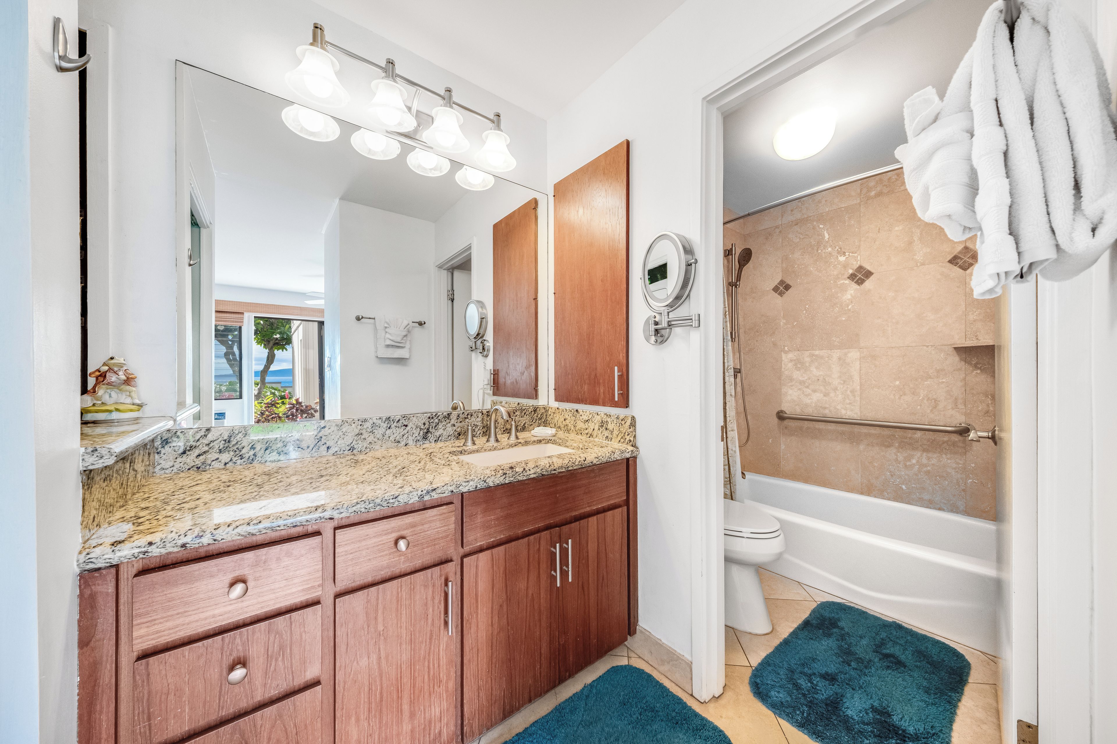 Une salle de bain équipée d’un lavabo, d’un miroir, d’un meuble-lavabo et d’une baignoire.
