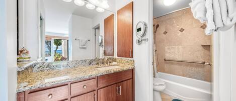 Une salle de bain équipée d’un lavabo, d’un miroir, d’un meuble-lavabo et d’une baignoire.