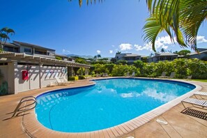 A swimming pool with lounge chairs and a covered area, surrounded by greenery and buildings. - Wailea Ekolu #501 Panoramic Ocean View, Ground Floor, Wifi, A/C, Near Beach (Wailea)