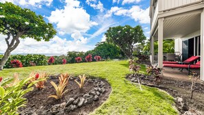 Un jardin aménagé avec une pelouse, un jardin de rocaille et une variété de plantes et d’arbres.