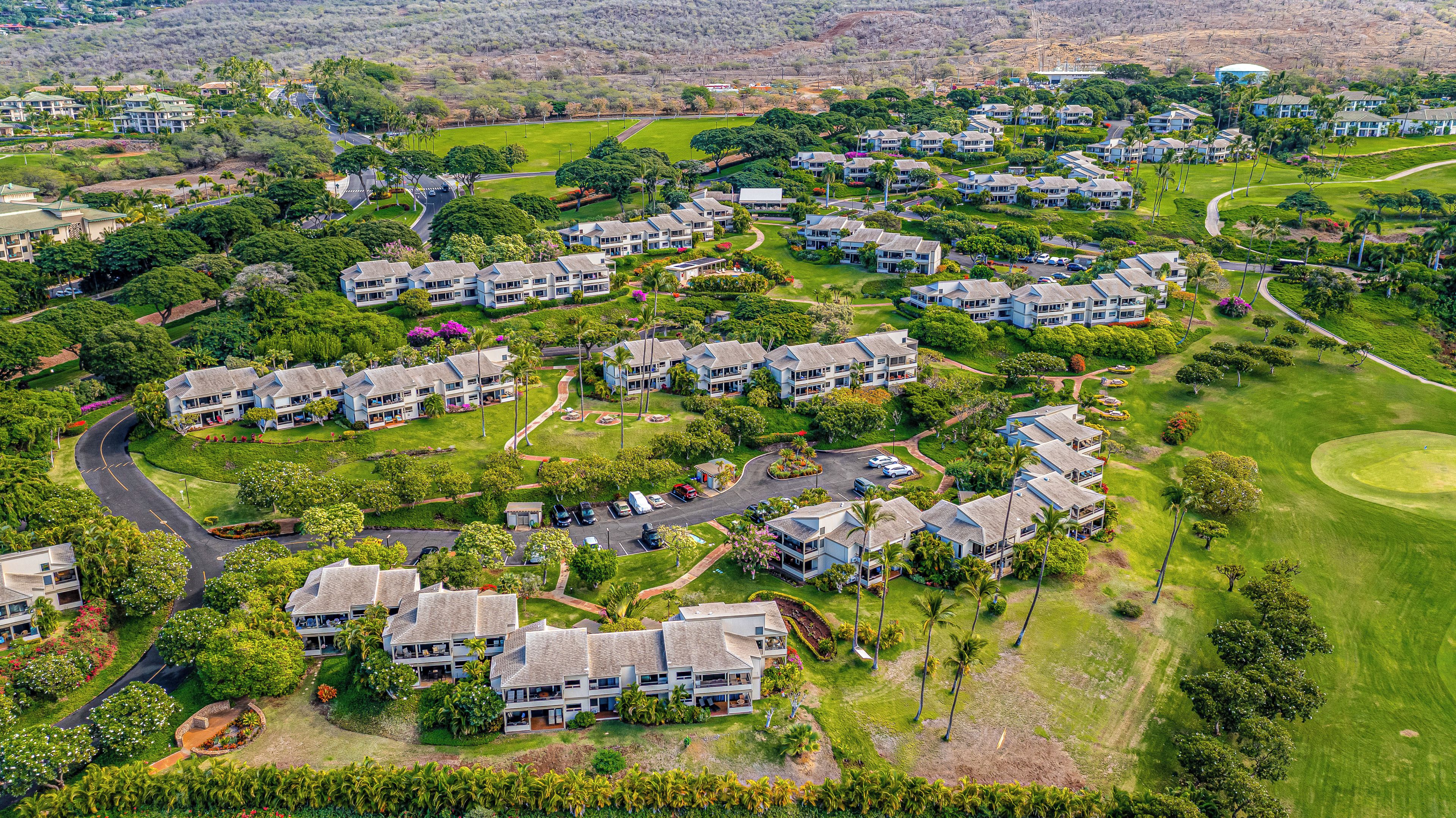 Un quartier résidentiel composé de plusieurs maisons à deux étages, de routes et d’espaces verts.