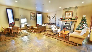 A spacious living room with a fireplace, a Christmas tree, and a stone fireplace surround. - Pool, Hot Tub, Elevator, Gym! Walk to River Trail, Festivals, Dining, Shops (Keystone)
