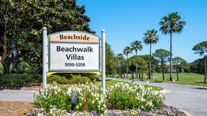 A sign for Beachside Beachwalk Villas with a landscaped garden and palm trees. - Lake Views ~ Golf Cart ~ Community Pool (Miramar Beach)