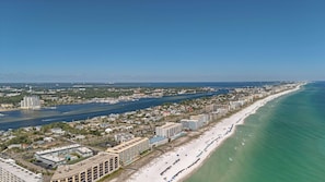 A coastal cityscape with a long beachfront, a river running parallel to the shore, and a mix of residential and commercial buildings.