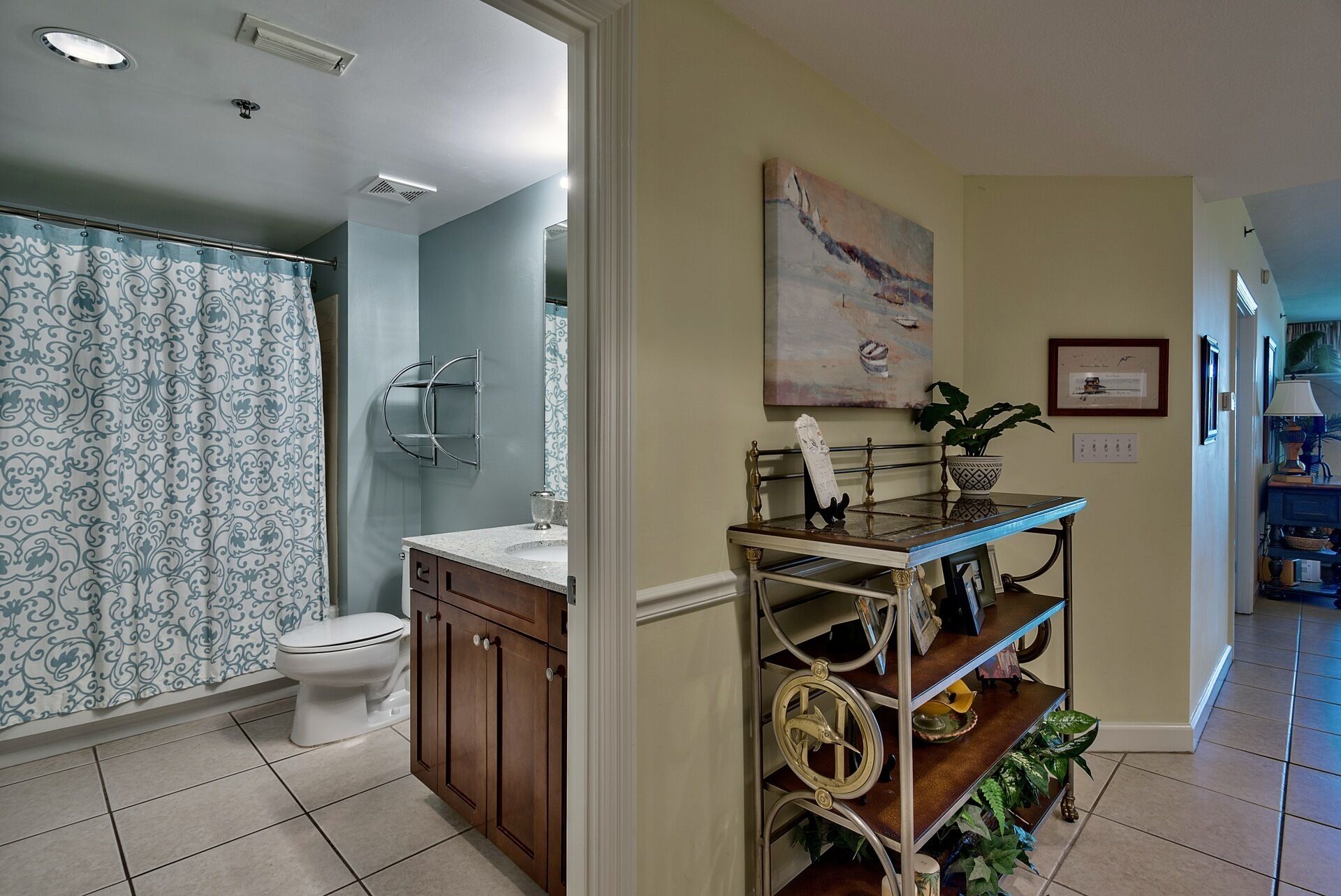 A bathroom with a toilet, vanity, and a shower area.