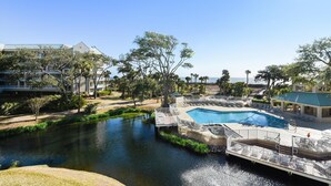 Un resort con piscina, río y vista a la playa.