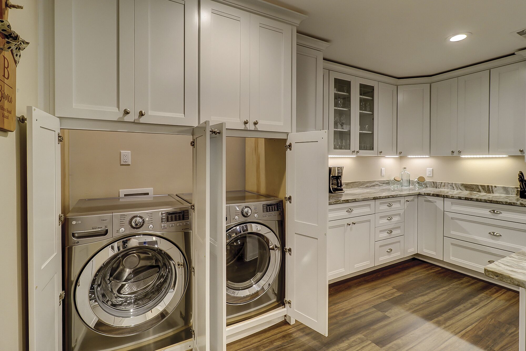 A kitchen with white cabinets, a built-in oven, and a countertop with a coffee maker.