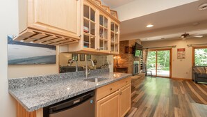 A kitchen with granite countertops, wooden cabinets, and a dishwasher. - Dog Friendly Lakefront Retreat w/ Pool & Hot Tub (McHenry)
