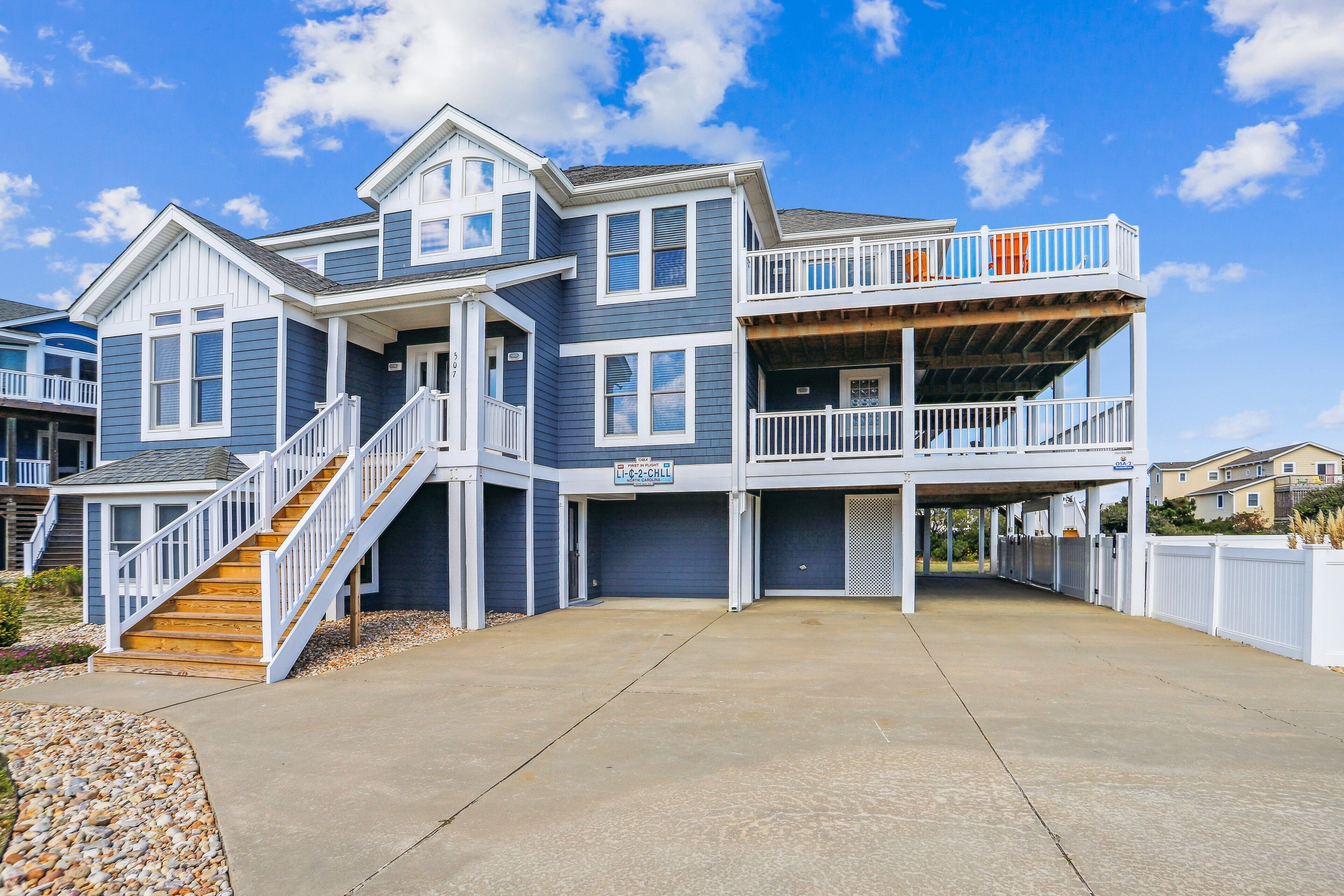 A two-story house with a covered front porch and a staircase leading to the upper level.