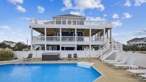 A two-story building with a pool and outdoor seating. - SEMI Oceanfront!  Beautiful decor, ocean vws! Noon check in! Pool, HotTub (Corolla)