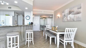 Una cocina moderna con armarios blancos, una isla central y taburetes de bar.