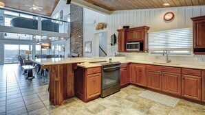 Une cuisine spacieuse avec des meubles en bois, un four encastré et un grand îlot central.