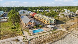 A coastal hotel with multiple buildings, a swimming pool, and a beach area. - Unit 032 - Sandcastle 5B (Dauphin  Island)
