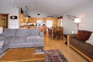 A living room with a grey sofa, a wooden coffee table, and a brown sofa with a patterned throw. - The Grand Escape - Great Duplex on Elk. Hot tub (Crested Butte)