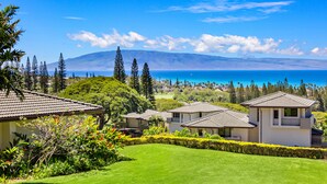 A residential area with houses, lush greenery, and a view of the ocean. - Celebrated Villa, stylish and stunning golf views (Lahaina)