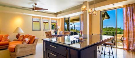 A modern kitchen with a central island, dining area with chairs, and a view of the outdoors.