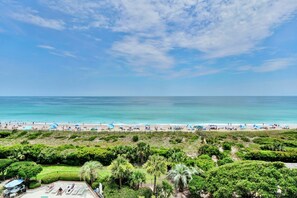 A beach with clear blue water, people sunbathing, and umbrellas. - Station One - 6J Beach Haven- Oceanfront condo with pool, tennis, beach (Wrightsville Beach)