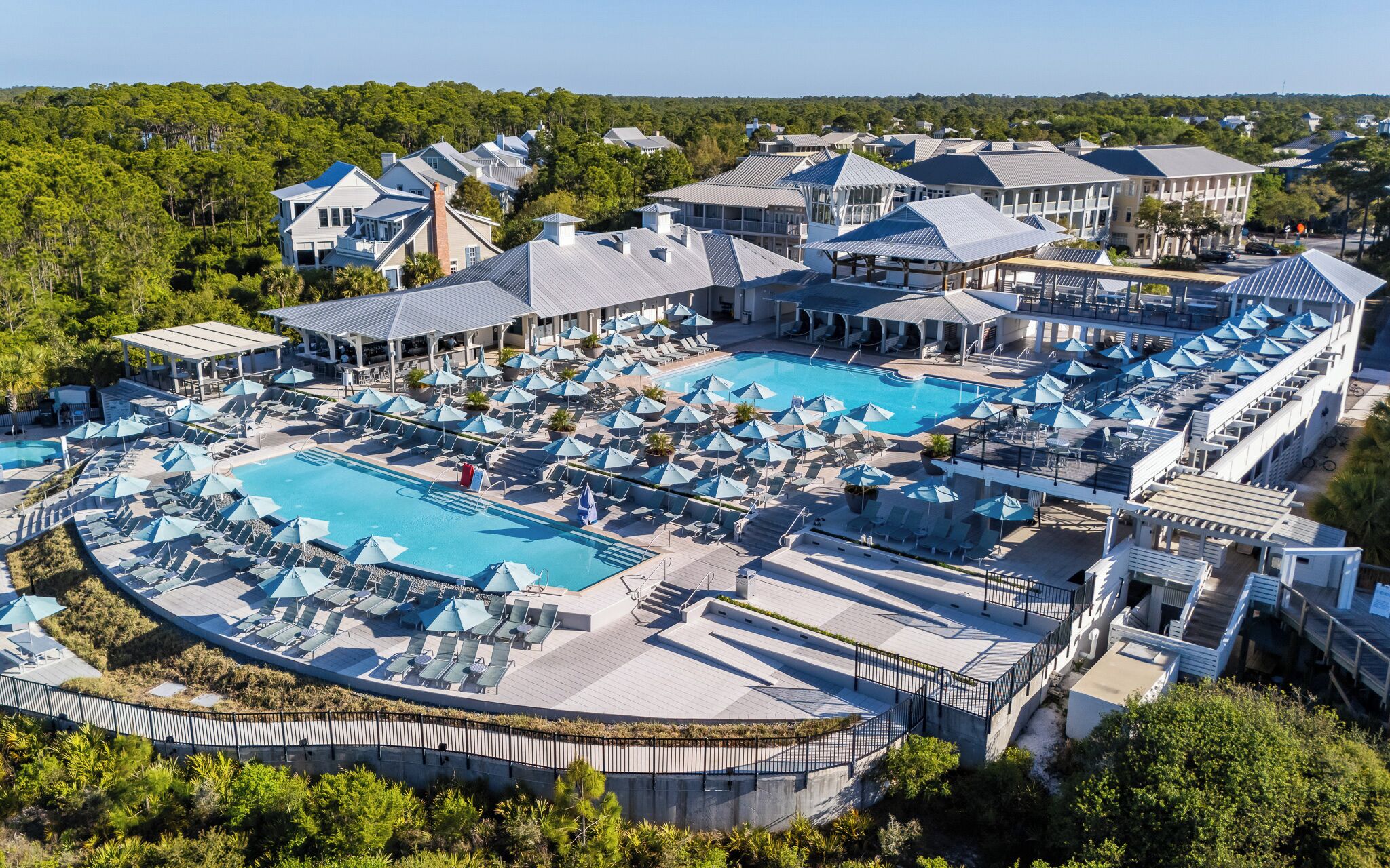 A resort with multiple swimming pools, sun loungers, and umbrellas.