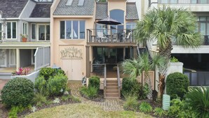 A two-story house with a balcony, a small garden, and a pathway leading to the entrance. - 17 Mizzenmast Ct - Amazing Views of 18th Fairway of Harbour Town Golf Links (Hilton Head Island)