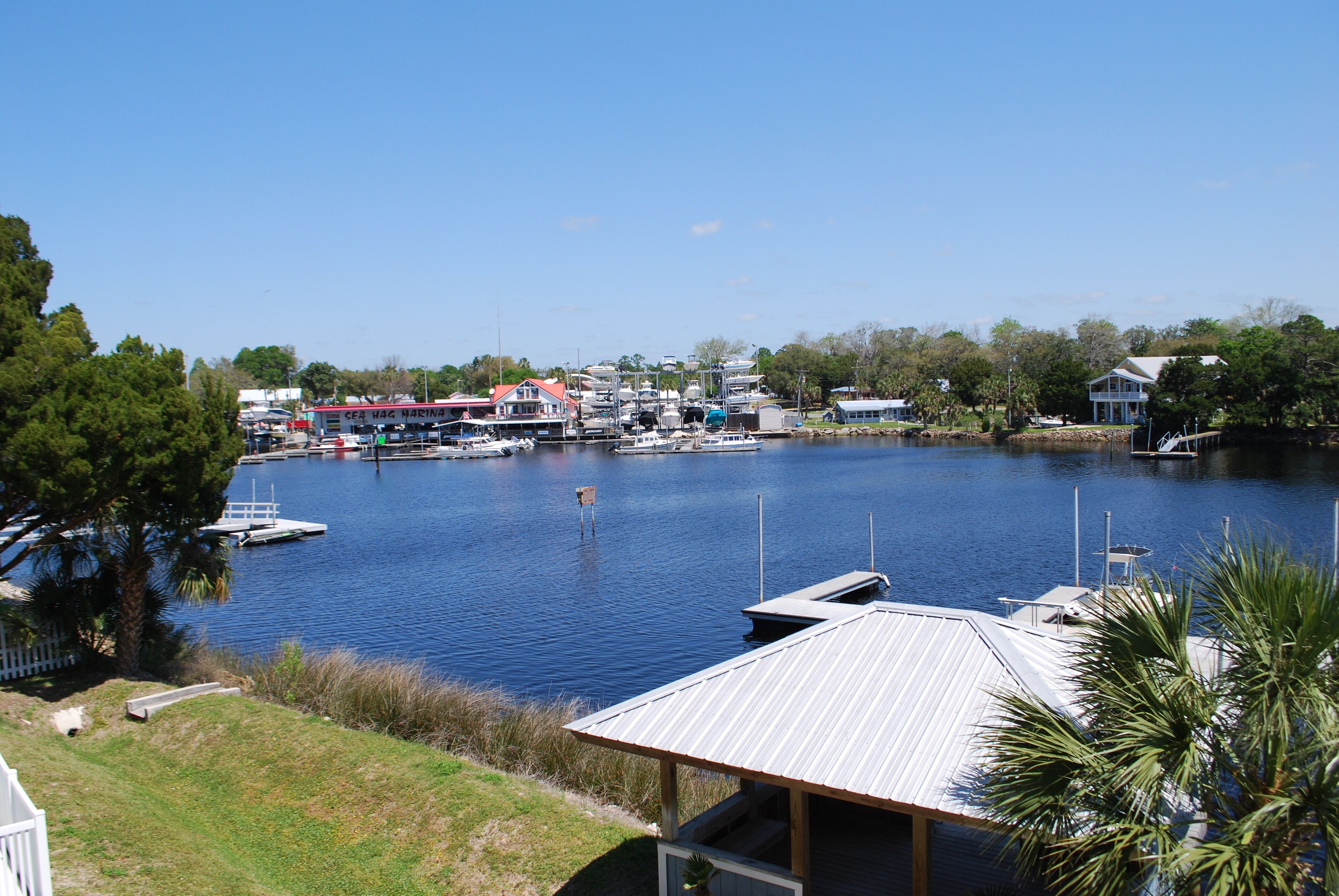 A marina with boats docked, a marina building, and a small dock.