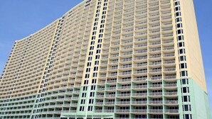 A high-rise hotel with multiple floors, balconies, and a uniform facade. - Gulf Front Main Bedroom Free round of Golf & Activities Every Day! (Panama City Beach)