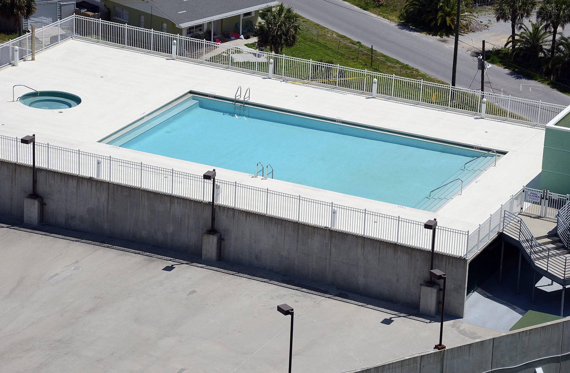 Une piscine rectangulaire bordée de blanc, avec une petite piscine circulaire à côté.