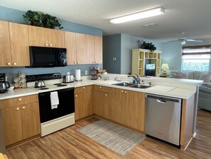 Una cocina moderna con armarios de madera, electrodomésticos de acero inoxidable y lavavajillas integrado.