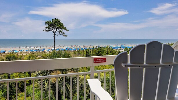 Blick auf einen Strand, mit einem Schild, das Grillverbot und das Verbot, Handtücher an der Brüstung aufzuhängen, anzeigt.