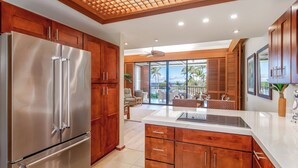 Una cocina moderna con armarios de madera, un refrigerador de acero inoxidable y una isla grande.