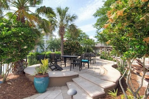 Relax in a serene outdoor space surrounded by lush greenery and comfortable seating.