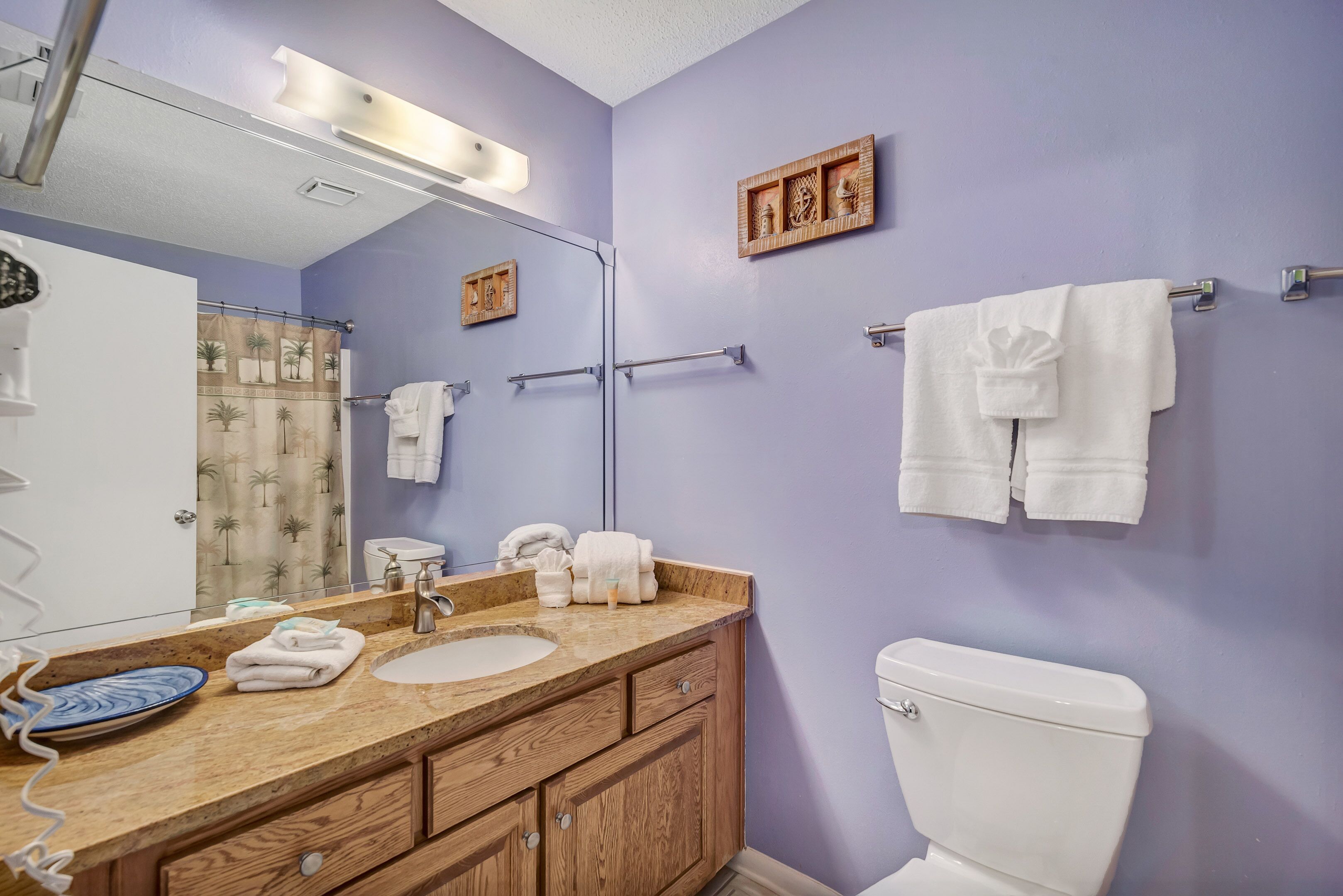 Een badkamer met een wastafel, spiegel, handdoekhouder en toilet.