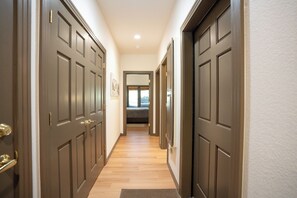 A hallway with wooden doors and a carpeted floor leading to a bedroom. - Elk Ridge Trail Townhome: Hot Tub, Spacious, Cool Location (Breckenridge)