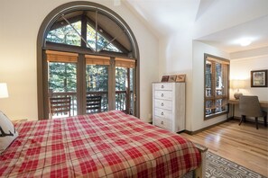 A bedroom with a large bed, a dresser, a chair, and a window with blinds. - Elk Ridge Trail Townhome: Hot Tub, Spacious, Cool Location (Breckenridge)