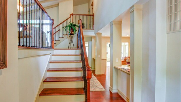 A spacious interior with a wooden staircase, a potted plant, and a view into the adjacent room. - 77 Plantation Dr - Walk to Harbour Town or Bike ride to Beach. (Hilton Head Island)