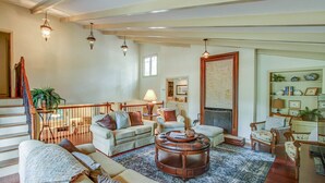 A spacious living room with a fireplace, a large rug, and a variety of seating options including a sofa and armchairs. - 77 Plantation Dr - Walk to Harbour Town or Bike ride to Beach. (Hilton Head Island)