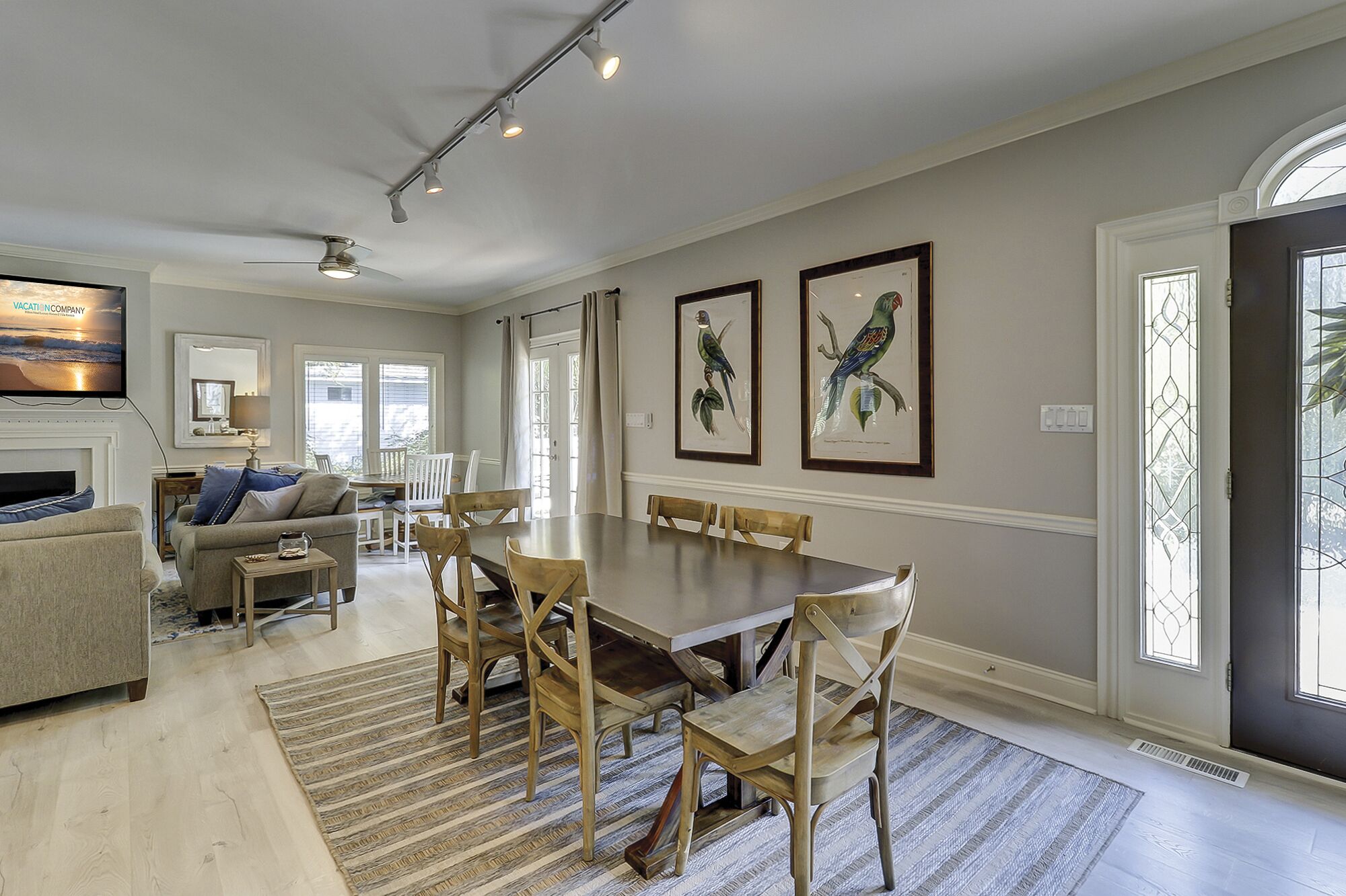 A spacious living room with a dining area, a fireplace, and framed artwork on the walls.