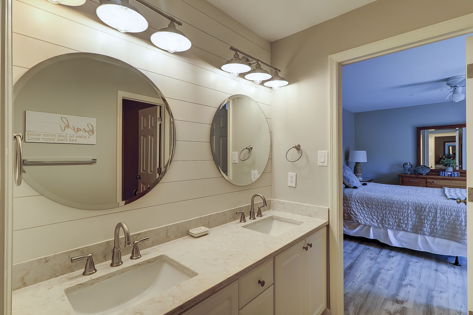 A bathroom with two sinks, a mirror, and a vanity with drawers.