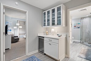 Una cucina moderna con mobili bianchi, lavastoviglie e un piano di lavoro con una lampada e oggetti decorativi.