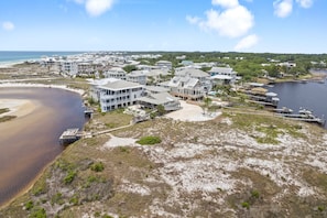 A coastal residential area with modern houses, a marina, and a beach.