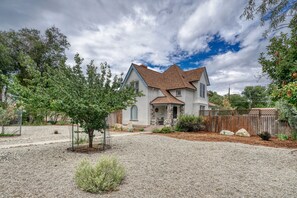 Une maison à deux étages avec une façade en pierre, un toit en tuiles et un porche à l’avant.