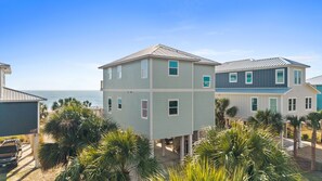 Coastal vacation homes with tropical landscaping near the waterfront, offering a peaceful beachside retreat. - Pelican Palms: 4 BR IP Beachfront Home- Sleeps 14, Pet Friendly, Priv. Pool! (Port St. Joe)