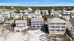 A coastal residential area with beachfront properties, including multi-story buildings with balconies and a sandy beach area. - Gulf Front - Beach Chairs - Seagrove Beach! (Santa Rosa Beach)