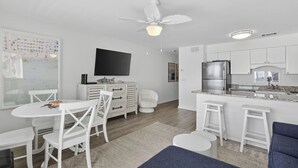 A modern kitchen with white cabinetry, a built-in stove, and a large island with bar stools. - Gulf Front - Beach Chairs - Seagrove Beach! (Santa Rosa Beach)