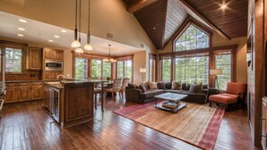 A spacious living area with a large window, wooden flooring, and a cozy seating arrangement.