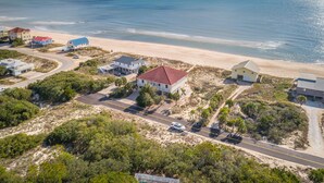 An aerial view of a coastal residential area with houses, a beach, and a road. - CASA DEL SOL - 4BR 4 BTH BEACHFRONT HOME W/POOL located in The Plantation (St, George Island)